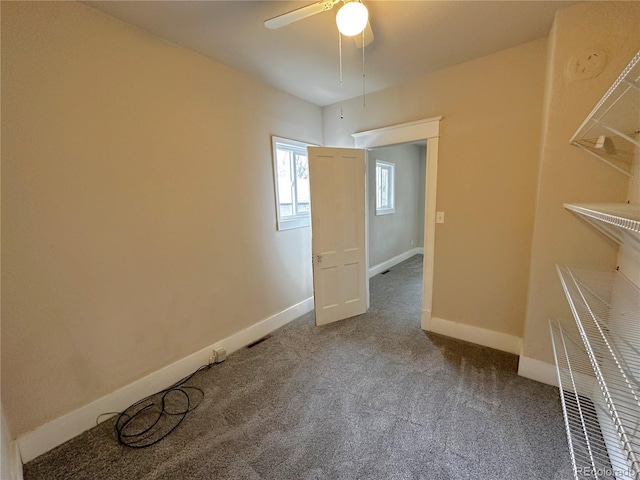 unfurnished room with a ceiling fan, baseboards, and carpet