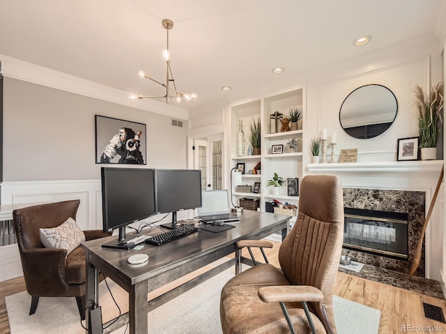 18963 E Long Ave, Centennial, CO 80016 - home office featuring a chandelier, a high end fireplace, a wainscoted wall, wood finished floors, and crown molding