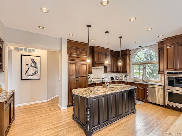18963 E Long Ave, Centennial, CO 80016 - kitchen with appliances with stainless steel finishes, decorative backsplash, recessed lighting, light wood-type flooring, and a center island