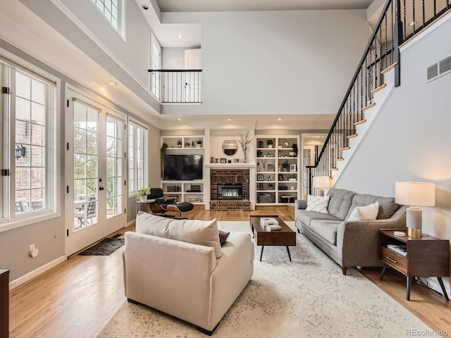 18963 E Long Ave, Centennial, CO 80016 - living area with a towering ceiling, healthy amount of natural light, wood finished floors, and a brick fireplace