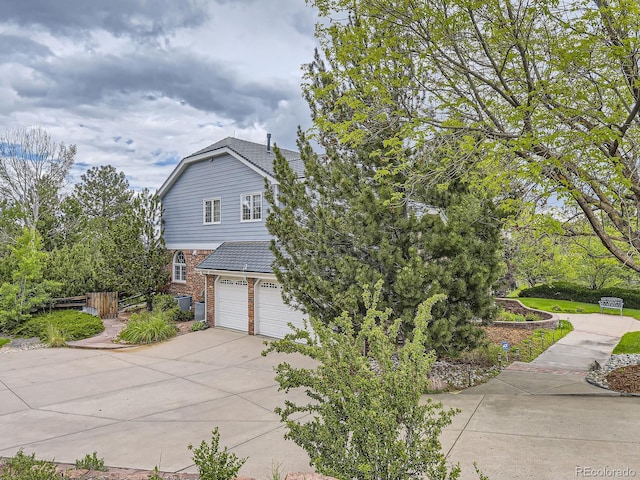 18963 E Long Ave, Centennial, CO 80016 - view of side of property featuring concrete driveway, a garage, and brick siding