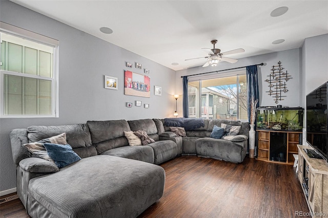 living room featuring ceiling fan and dark hardwood / wood-style floors