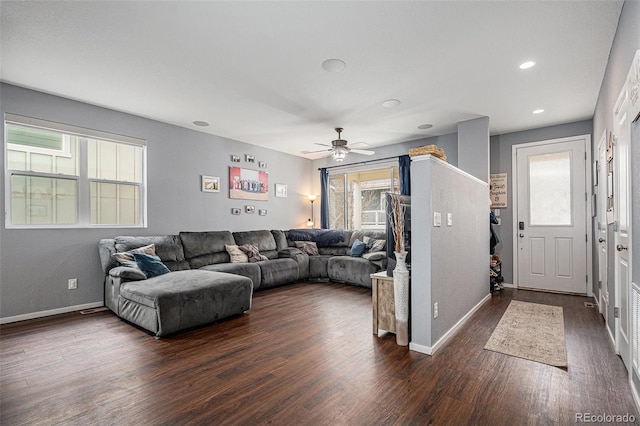 living room featuring ceiling fan, dark wood-type flooring, and a healthy amount of sunlight