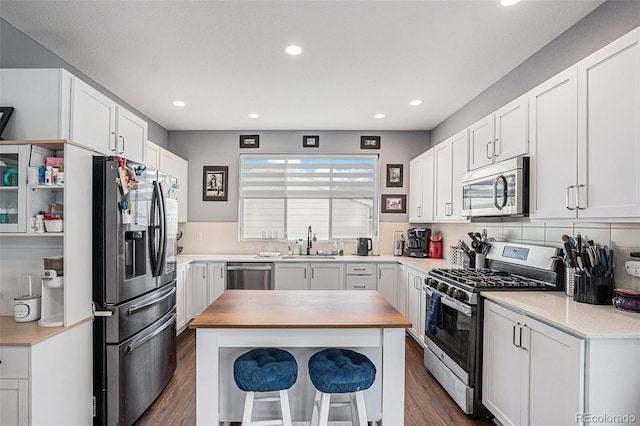 kitchen with white cabinets, sink, appliances with stainless steel finishes, and tasteful backsplash