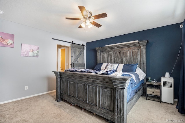 bedroom featuring ceiling fan, a barn door, and light colored carpet