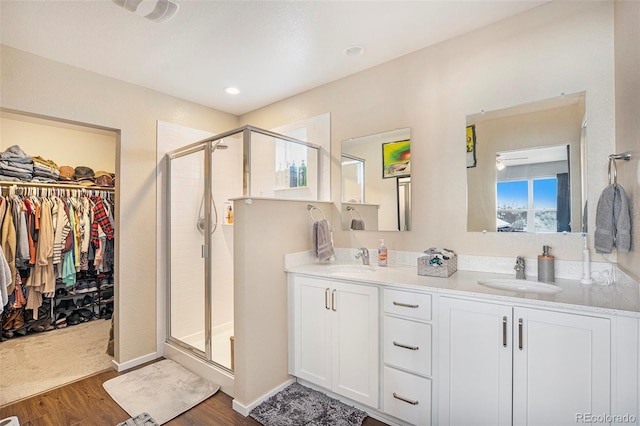 bathroom featuring hardwood / wood-style flooring, vanity, and a shower with door