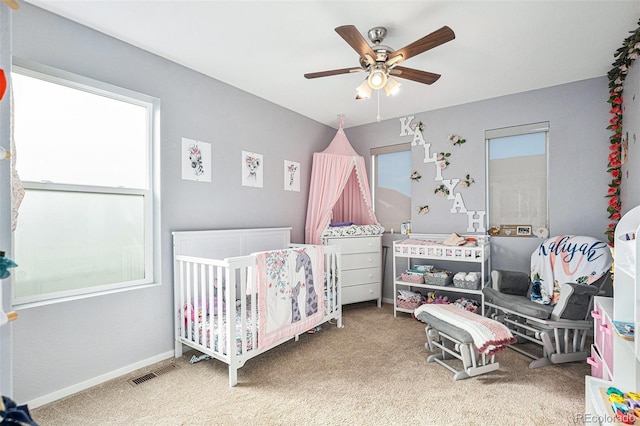 bedroom featuring ceiling fan, carpet floors, and a nursery area