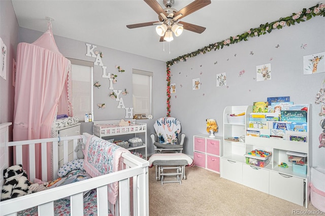 bedroom featuring ceiling fan, carpet, and a crib