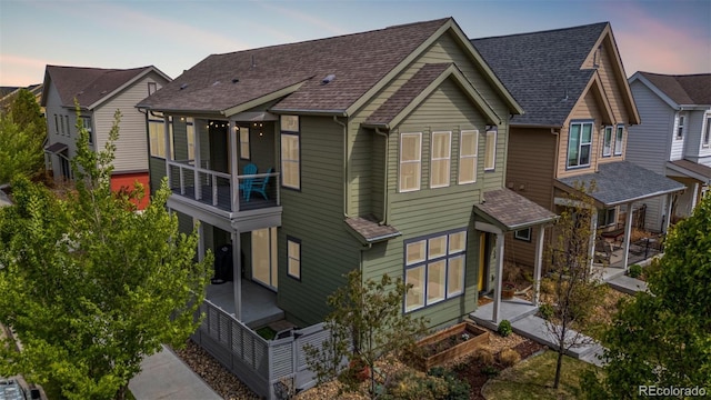 1754 W 66th Ave, Denver, CO 80221 - back of property at dusk featuring a balcony and roof with shingles