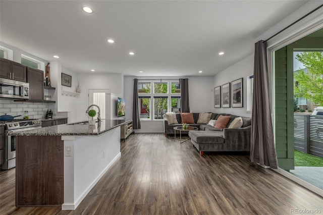 1754 W 66th Ave, Denver, CO 80221 - kitchen with stainless steel appliances, dark stone counters, dark wood-type flooring, a sink, and recessed lighting