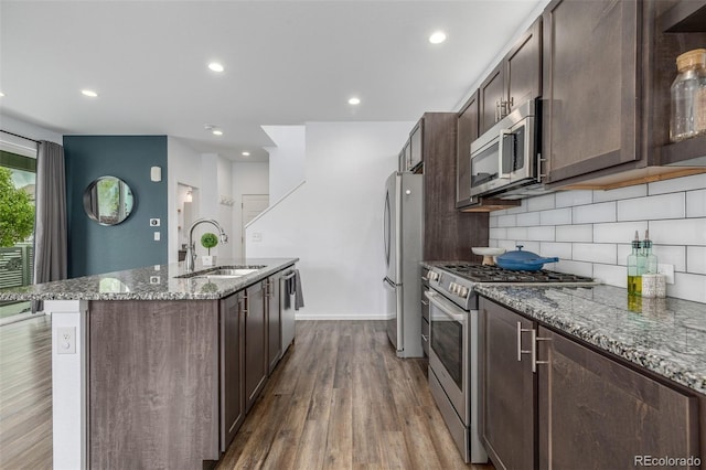 1754 W 66th Ave, Denver, CO 80221 - kitchen featuring stainless steel appliances, a sink, wood finished floors, dark brown cabinets, and recessed lighting