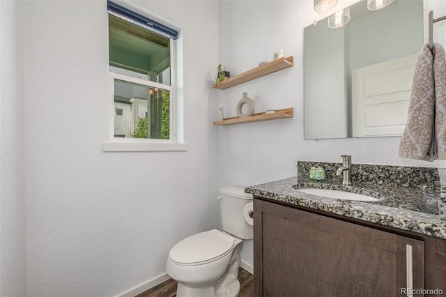 1754 W 66th Ave, Denver, CO 80221 - half bath with baseboards, vanity, wood finished floors, and toilet