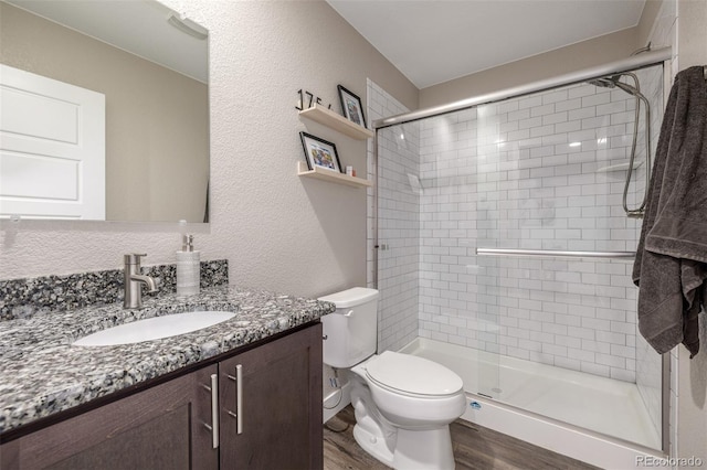 1754 W 66th Ave, Denver, CO 80221 - full bath with vanity, wood finished floors, a shower stall, toilet, and a textured wall