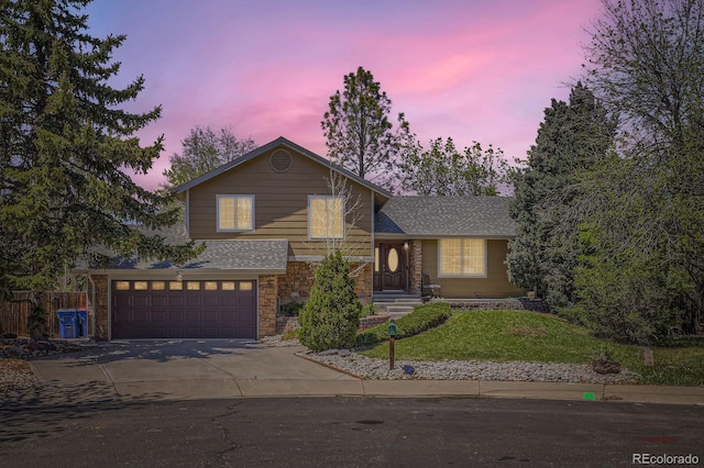 1973 S Pitkin St, Aurora, CO 80013 - tri-level home featuring driveway, stone siding, an attached garage, and a shingled roof