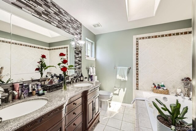1973 S Pitkin St, Aurora, CO 80013 - bathroom with a bath, toilet, tile walls, double vanity, and tile patterned flooring