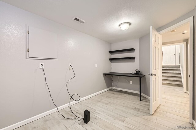 1973 S Pitkin St, Aurora, CO 80013 - laundry room with light wood-type flooring, baseboards, and a textured ceiling