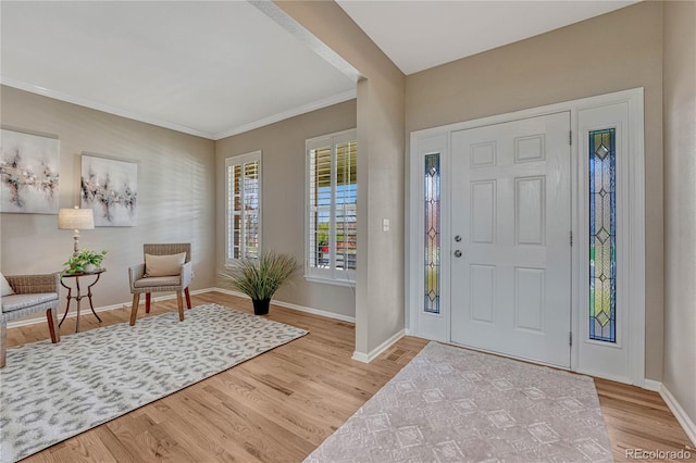 entrance foyer featuring baseboards, ornamental molding, and wood finished floors