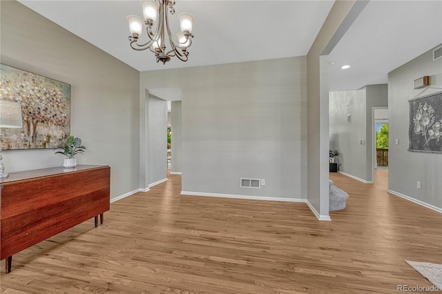 dining space featuring a notable chandelier, baseboards, visible vents, and wood finished floors