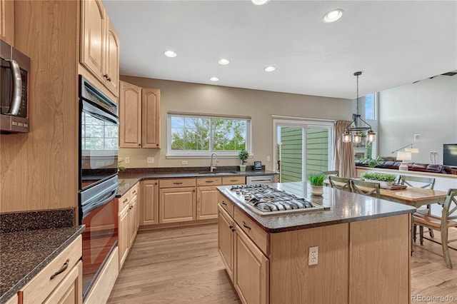 kitchen featuring appliances with stainless steel finishes, a sink, light wood finished floors, light brown cabinets, and recessed lighting