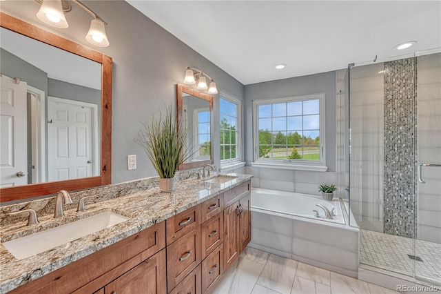 full bathroom featuring a sink, double vanity, a stall shower, and a bath