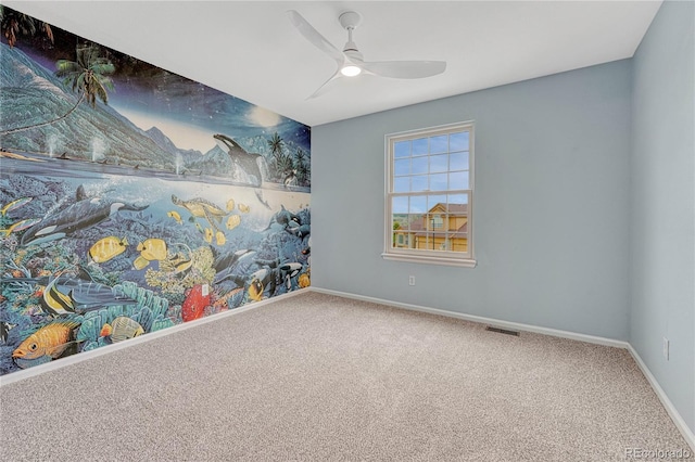 carpeted empty room featuring baseboards, a ceiling fan, and visible vents