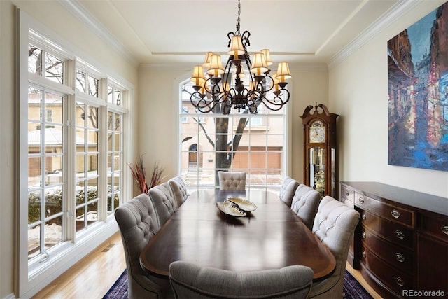 dining space with a chandelier, crown molding, and wood finished floors