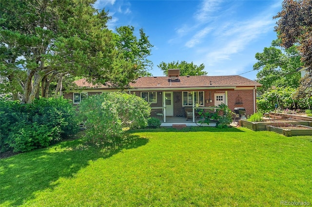 5047 S Mabre Ct, Littleton, CO 80123 - back of property with a vegetable garden, a lawn, brick siding, and a patio