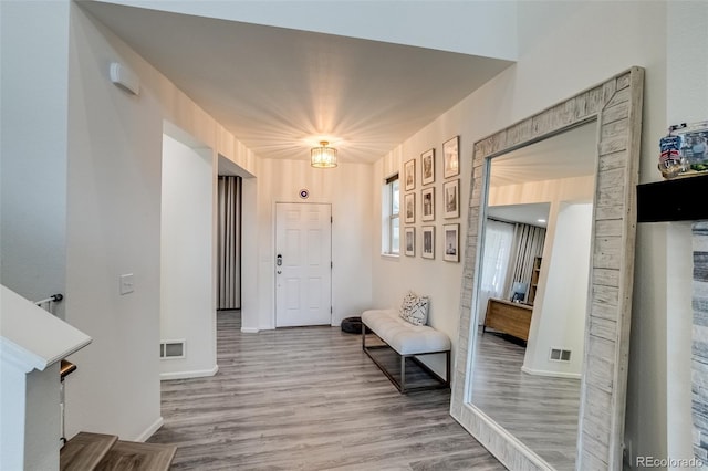 entryway with wood finished floors, baseboards, and a heating unit