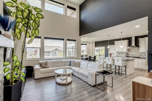 living room with light wood-style floors and a towering ceiling