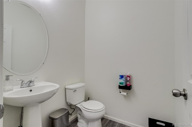 bathroom featuring toilet, wood finished floors, and baseboards