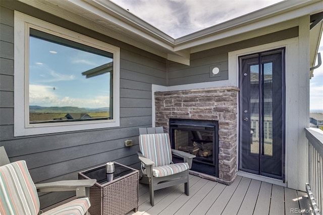 wooden terrace with a glass covered fireplace