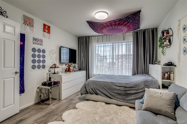 bedroom with wood finished floors and baseboards