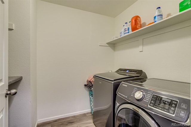 laundry area featuring washer and clothes dryer, wood finished floors, and baseboards