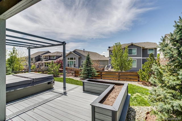 wooden terrace with a hot tub, a residential view, and a pergola