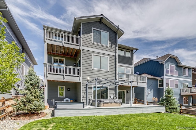 back of property with a balcony, a lawn, and a patio