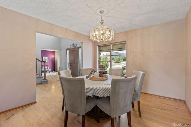 9447 Chesapeake St, Highlands Ranch, CO 80126 - dining area with a chandelier, light wood-style flooring, a textured ceiling, and stairs