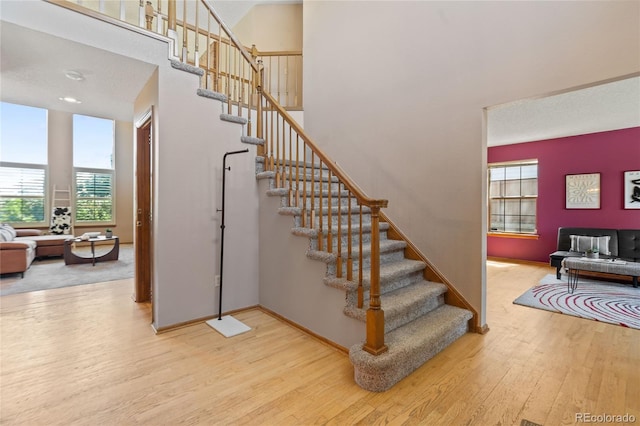 9447 Chesapeake St, Highlands Ranch, CO 80126 - staircase with wood finished floors, healthy amount of natural light, and a high ceiling