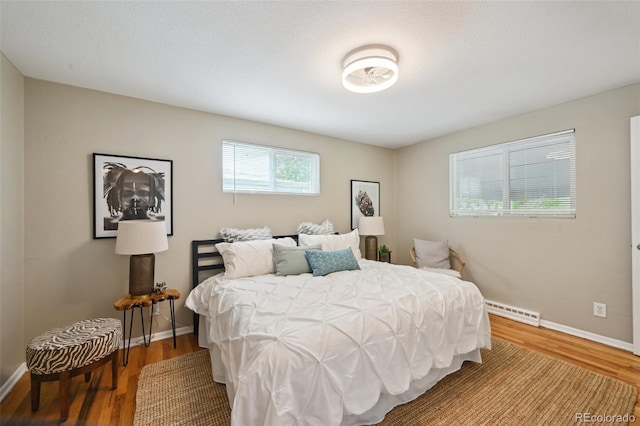 1646 S Stuart St, Denver, CO 80219 - bedroom with a baseboard radiator, wood finished floors, and baseboards