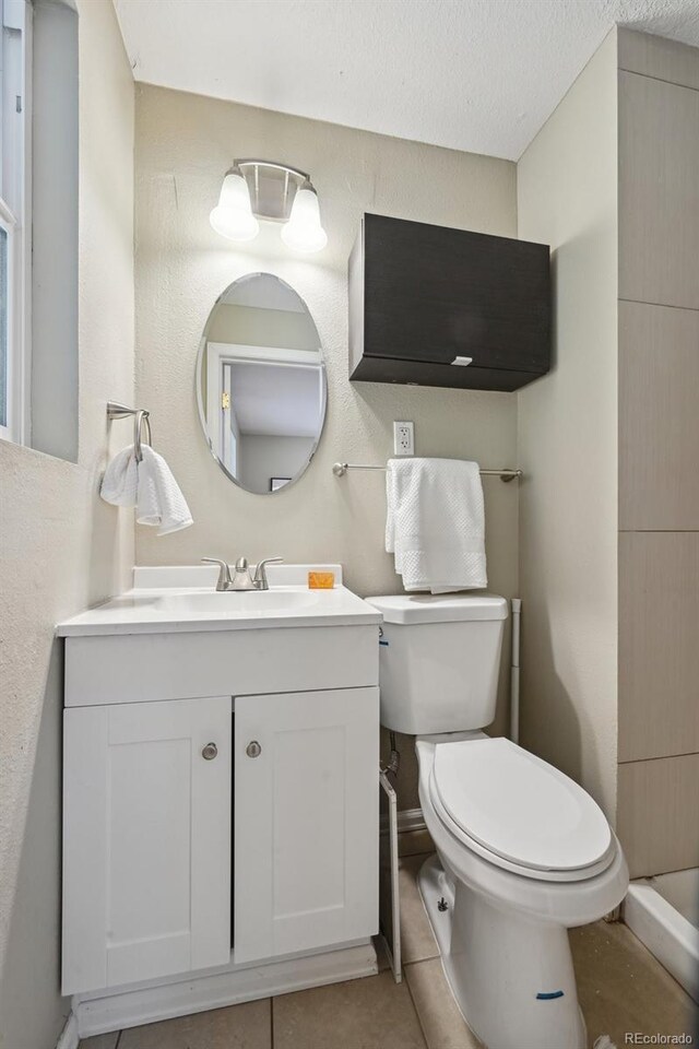 1646 S Stuart St, Denver, CO 80219 - bathroom featuring toilet, vanity, and tile patterned flooring
