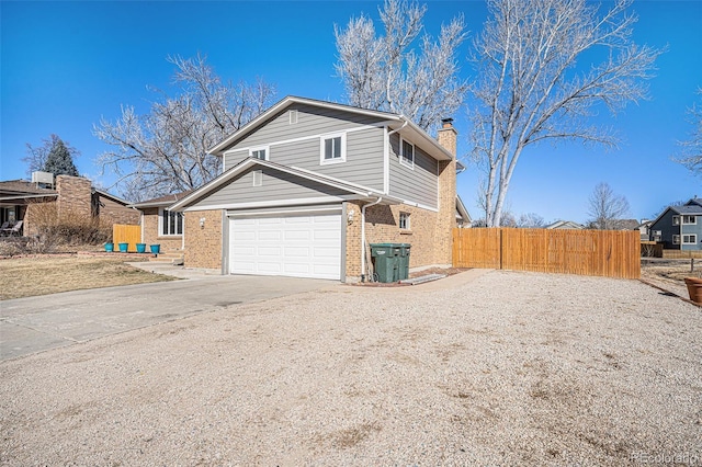 view of home's exterior with a chimney, fence, concrete driveway, and brick siding