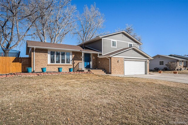 tri-level home with brick siding, concrete driveway, an attached garage, a front yard, and fence