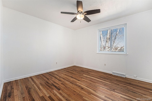 unfurnished room featuring a ceiling fan, baseboards, visible vents, and dark wood-style flooring