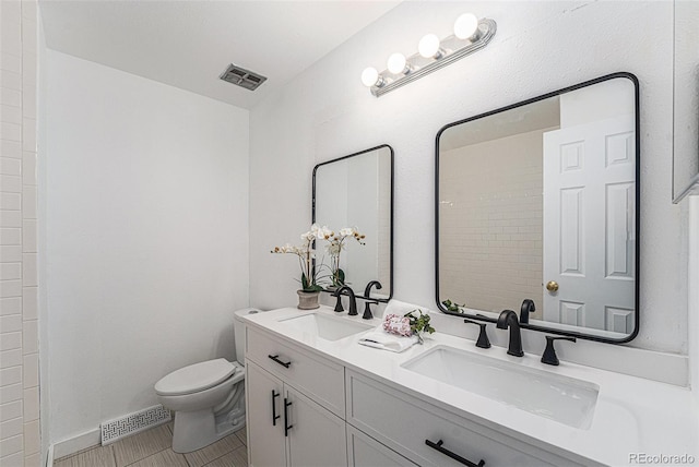 full bathroom featuring toilet, a sink, and visible vents