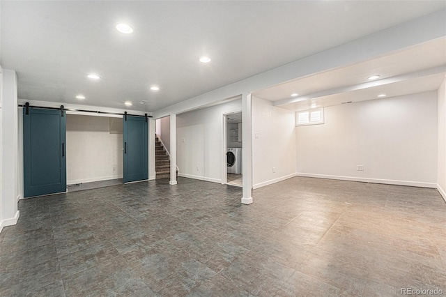 below grade area featuring recessed lighting, washer / clothes dryer, baseboards, and a barn door