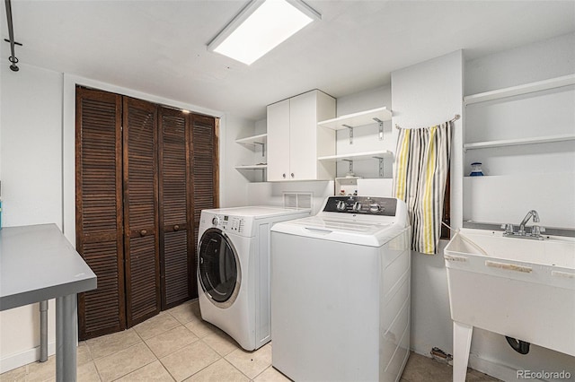 laundry room with cabinet space, independent washer and dryer, a sink, and light tile patterned floors