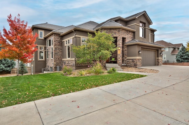 14022 E Fair Pl, Centennial, CO 80111 - prairie-style house featuring stone siding, stucco siding, a garage, driveway, and a front lawn