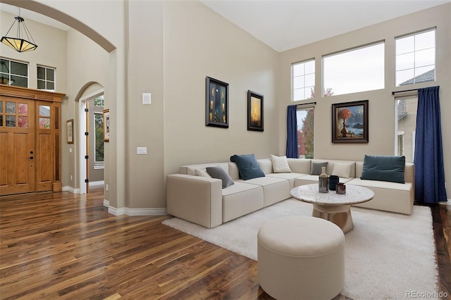 14022 E Fair Pl, Centennial, CO 80111 - living room featuring a high ceiling, dark wood finished floors, arched walkways, and baseboards
