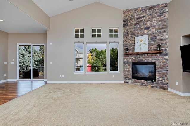 14022 E Fair Pl, Centennial, CO 80111 - unfurnished living room with carpet flooring, a stone fireplace, baseboards, and high vaulted ceiling