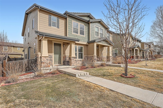 view of front of house with a residential view, stone siding, a front yard, and fence