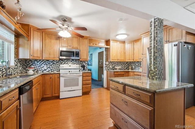 1922 Graves Ct, Northglenn, CO 80233 - kitchen featuring stainless steel appliances, decorative backsplash, light wood finished floors, a ceiling fan, and light stone countertops